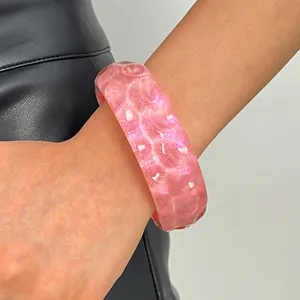 Close-up detail of vintage pink marbled resin wide bangle bracelet with glossy finish