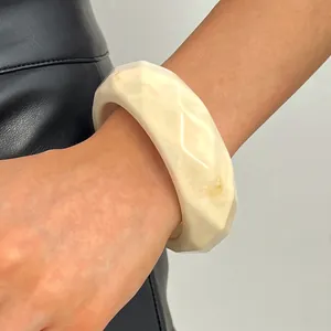 Vintage cream resin wide bangle with a faceted marble pattern shown on model's wrist