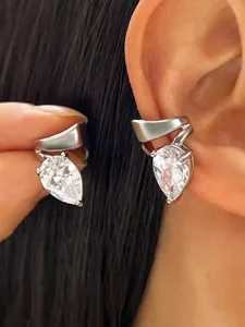 Close-up detail of an elegant teardrop zirconia ear clip with curved silver-tone lines.