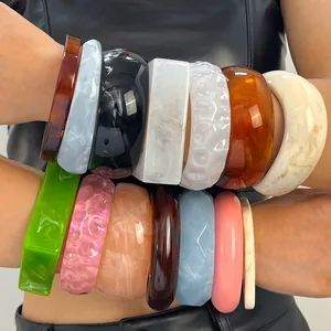 Close-up detail of various colorful marbled and tortoise shell resin bangles for women