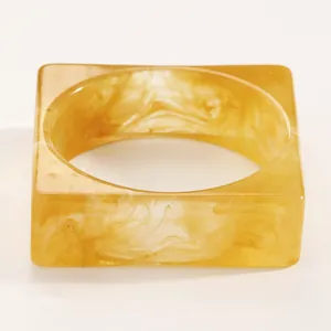 Close-up detail of vintage amber marbled resin square bangle showing swirled texture