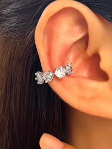 Detailed view of elegant silver ear cuff with four round zircons worn on ear cartilage