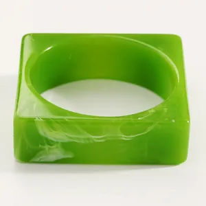 Close-up of vintage green resin bangle with white marble pattern and square design