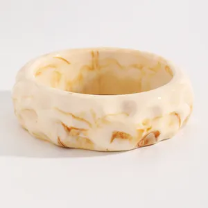 Macro detail of retro marbled resin wide bangle showing unique hammered texture and swirled patterns
