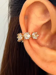 Close-up detail of a gold-plated ear cuff with three sparkling round cubic zirconia