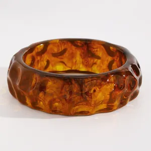 Detail view of a vintage amber marbled resin bangle with unique rippled texture surface