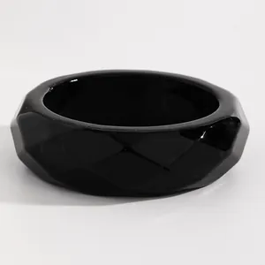 Detailed view of a minimalist black retro resin wide bangle with faceted geometric design