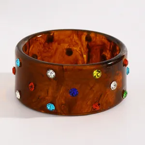 Detailed view of vintage tortoiseshell resin bangle decorated with vibrant multi-color crystals