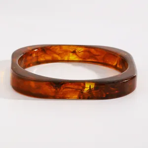 Close-up of vintage marbled amber resin wide bangle showing unique swirl patterns