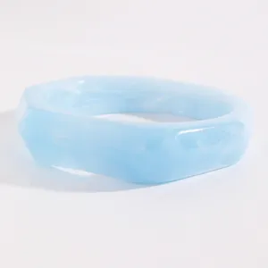 Detail view of a vintage light blue marbled resin bangle with geometric faceted edges.