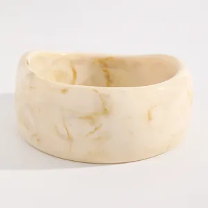 Wide marbled resin bangle bracelet with cream and yellow tie-dye patterns for women