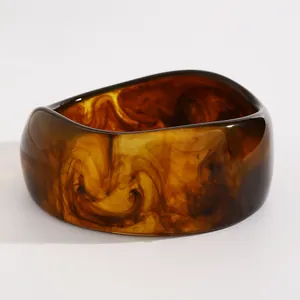 Macro view of vintage marbled amber resin chunky bangle featuring unique swirl patterns