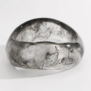 Detailed view of a vintage resin bangle featuring an artistic black ink wash marble pattern