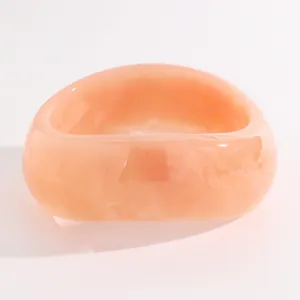 Close-up of a vintage orange marbled resin wide bangle with smooth polished finish