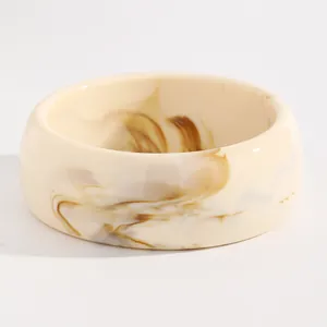 Close-up of vintage marbled resin wide bangle with cream and brown swirl pattern