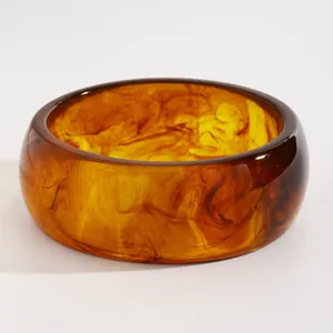 Detailed close-up of a vintage amber marble resin wide bangle with unique swirl patterns