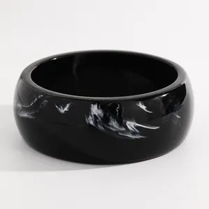 Close-up of vintage black resin bangle with white ink-wash marbled pattern detail