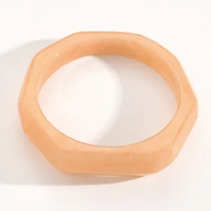 Close-up detail of a retro marbled peach resin wide bangle with smooth octagonal shape