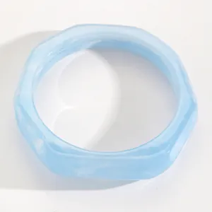 Close-up of light blue marbled resin bangle with unique hexagonal geometric shape