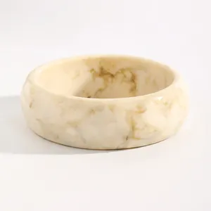 Close-up detail of a vintage marbled resin wide bangle with cream and brown patterns