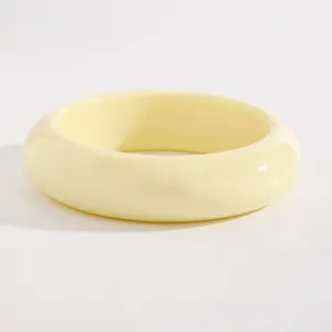 Detail view of a vintage style chunky cream yellow resin bangle with smooth finish