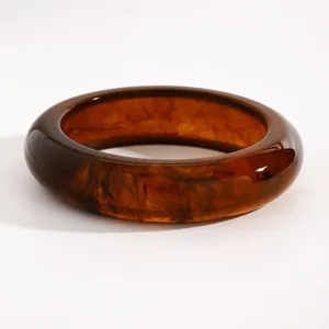 Close-up detail of retro marbled resin bangle featuring vintage amber swirled texture