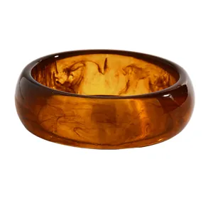 Macro detail of retro marbled amber resin bangle showing unique swirl textures and colors