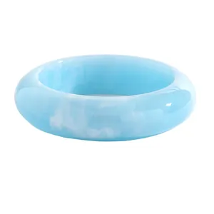 Detailed macro view of retro light blue marbled resin bangle with elegant white swirl patterns