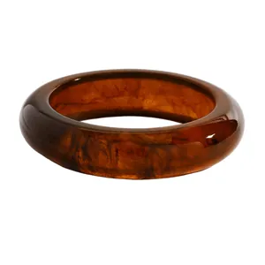 Detailed close-up showing the marbled texture of a vintage amber resin wide bangle bracelet