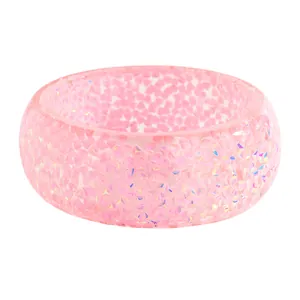 Close-up view of a pink resin wide bangle featuring embedded iridescent glitter texture