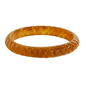 Close-up of a retro amber marbled resin bangle with a twisted ribbed texture