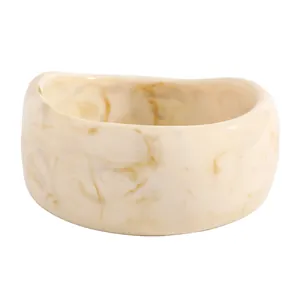 Detailed close-up showing the textures of a vintage cream resin bangle with brown marble patterns.