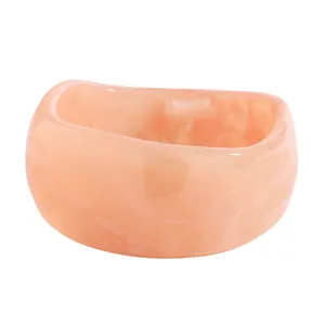 Close-up view of a vintage pink marble resin wide bangle bracelet featuring elegant marbling