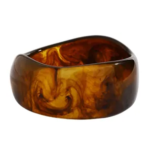 Detailed view of a wide resin bangle featuring elegant brown marbleized swirl patterns