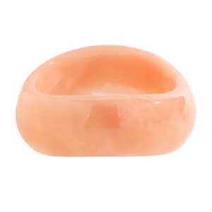 Macro detail of a vintage marbled resin wide bangle with a smooth glossy finish