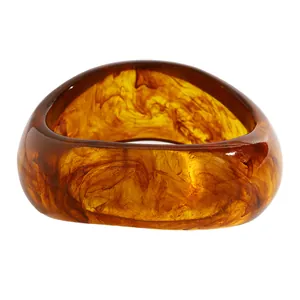 Close-up of retro marbled resin wide bangle with amber brown swirl patterns for women.