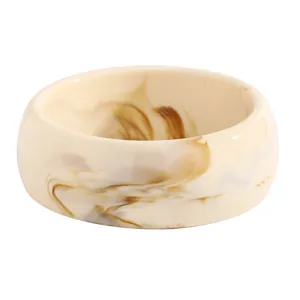 Detailed view of a retro wide resin bangle featuring a brown marbled pattern on cream.