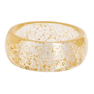 Macro view of clear chunky resin bangle featuring elegant gold foil gold leaf flakes