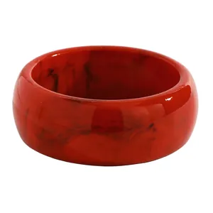 Detailed macro view of a vintage red marble-patterned resin wide bangle bracelet.