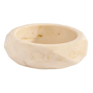 Close-up detailed view of a creamy white marbled resin bangle with geometric facets
