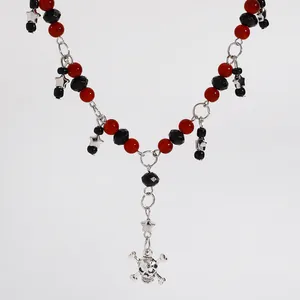 Gedetailleerd aanzicht van punk ketting met rood zwarte kralen, sterren en schedel.