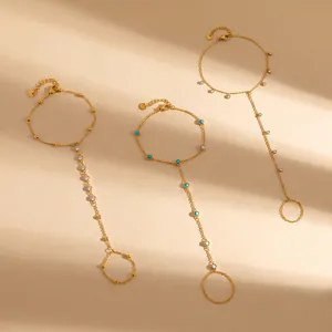 Détail de bijoux de main en acier inoxydable doré avec zircons et pierres turquoise