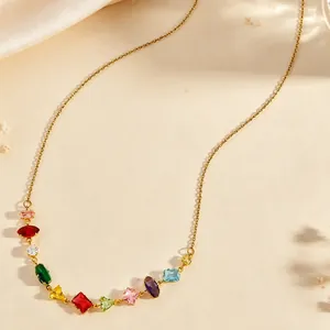 Close-up detail of a gold necklace featuring multi-shaped and colorful cubic zirconia stones