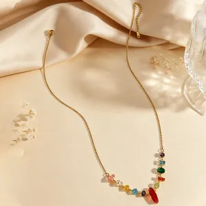 Close-up of a delicate gold necklace featuring vibrant, multi-colored cubic zirconia gemstones.