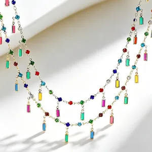 Close-up of colorful rectangle and round zircon gemstones on a gold collarbone chain detail