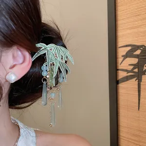 Close-up of green bamboo embroidery hair clip with elegant tassels on a hair bun.
