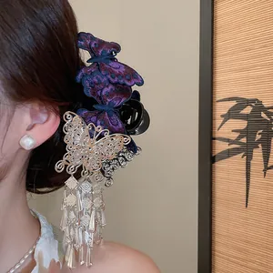 Detailed close-up of elegant purple butterfly embroidered hair clip with silver tassels on hair