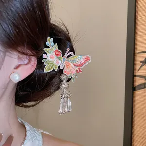 Detail of embroidered butterfly hair clip with metallic tassels and flower accents