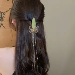 Close-up of vintage butterfly embroidery hair clip with long golden tassels on long hair