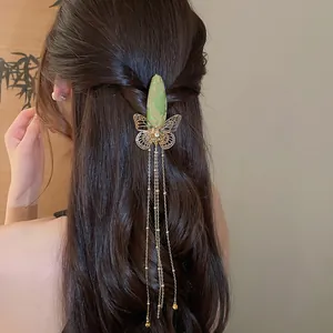 Detailed view of an elegant New Chinese butterfly hair clip with long gold tassels